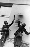 German soldiers removing the Polish national emblem from one of the offices in Gdynia, September 1939 (BArch)